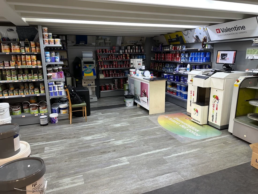Zona de preparación del color con máquinas y pinturas en la tienda